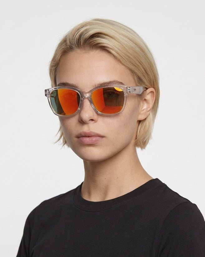 Delta 9 oversized round sunglasses in Orange / Clear, orange lens on clear frame, worn by a woman, front view