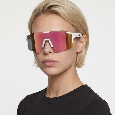 Dial Up sport shield sunglasses in Pink / White, pink lens on white frame, worn by a woman, front view