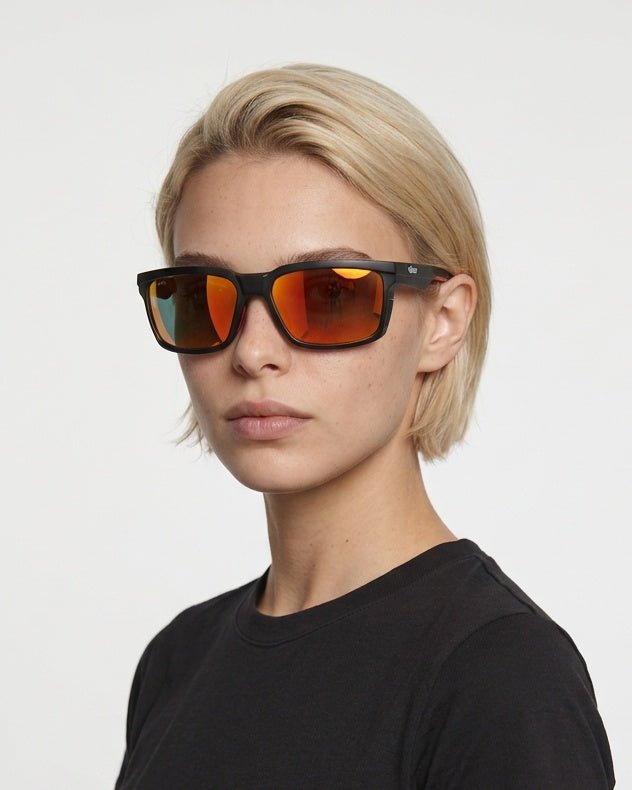 Flux sport wrap sunglasses in Orange / Black, orange lens on black frame, worn by a woman, front view