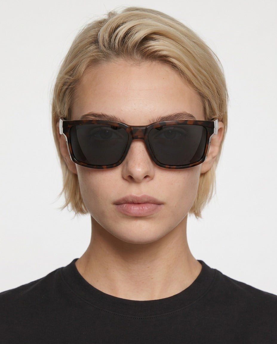 Flux sport wrap sunglasses in Black / Tortoise, black lens on tortoise frame, worn by a woman, front view