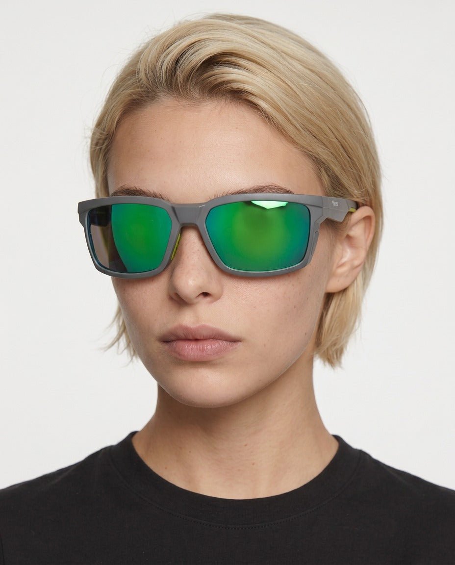 Flux sport wrap sunglasses in Green / Smoke Grey, green lens on smoke grey frame, worn by a woman, front view