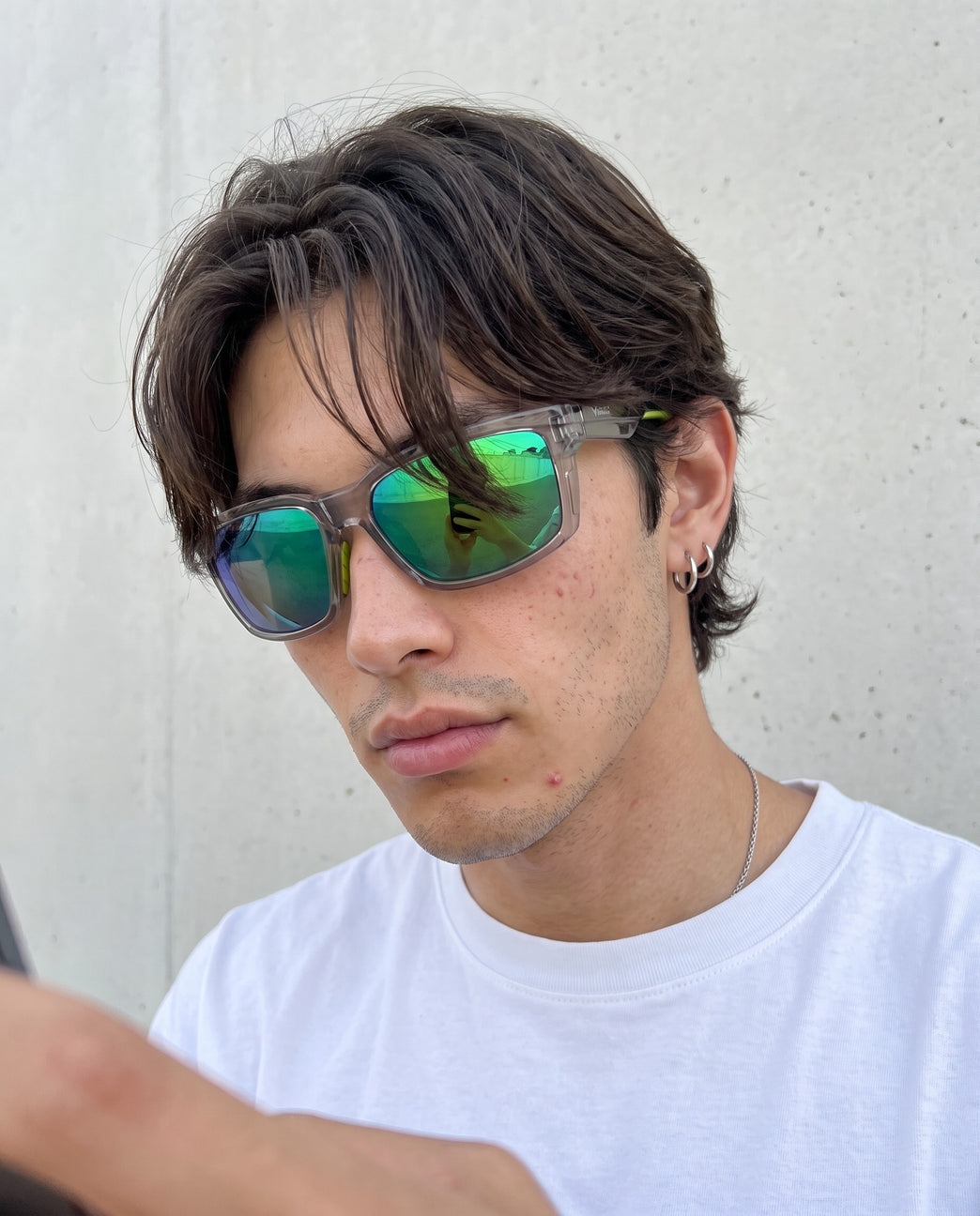 Young man in a white tee wearing Vibes Flux sunglasses with green mirror lenses