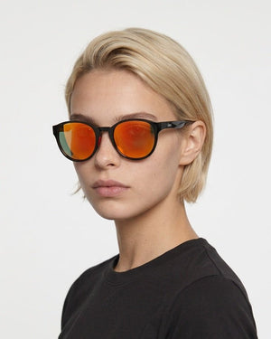 Hollis retro round sunglasses in Orange / Black, orange lens on black frame, worn by a woman, front view