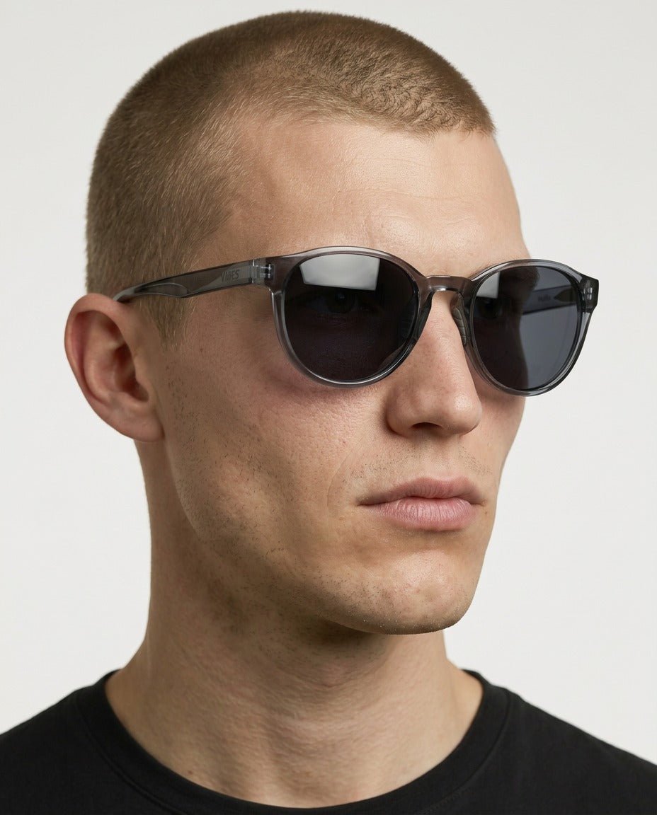 Hollis retro round sunglasses in Grey / Clear Grey, grey lens on clear grey frame, worn by a man, front view