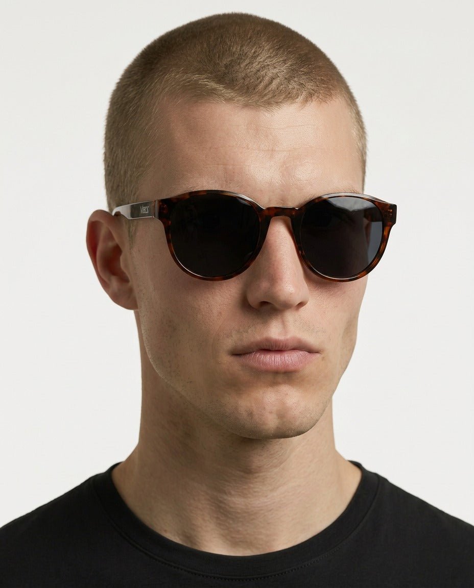 Hollis retro round sunglasses in Black / Tortoise, black lens on tortoise frame, worn by a man, front view