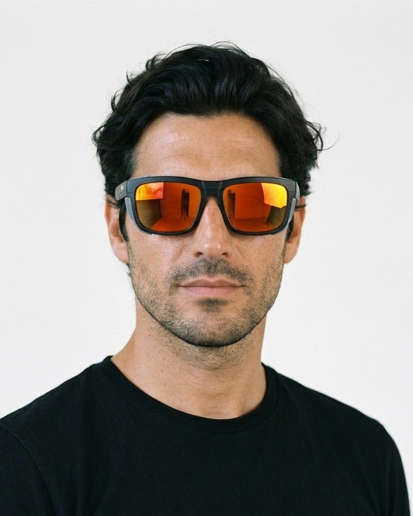 Juno side-shield wrap sunglasses in Orange / Black, orange lens on black frame, worn by a man, front view