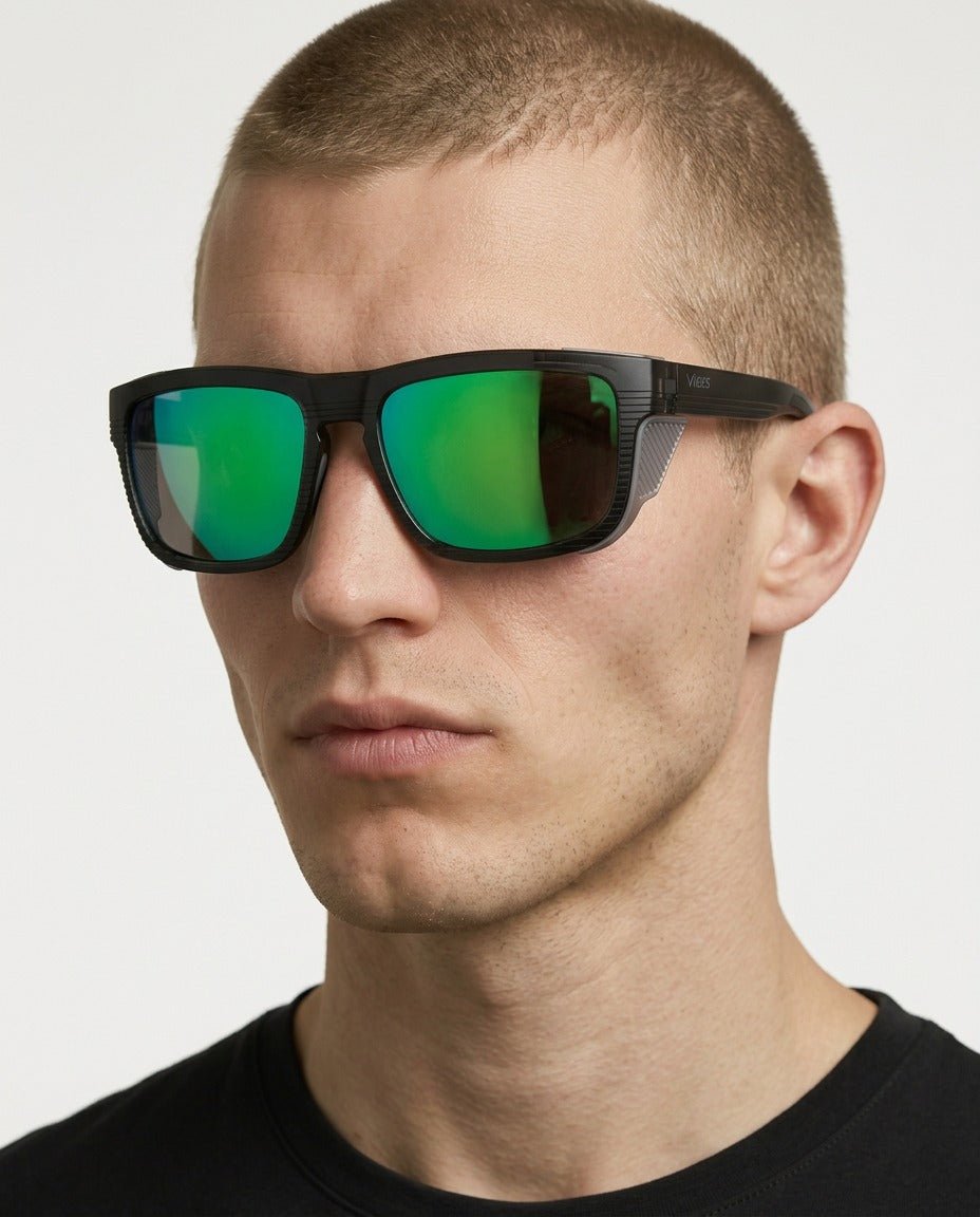 Juno side-shield wrap sunglasses in Green / Black, green lens on black frame, worn by a man, front view