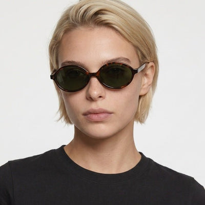 Mojave slim oval metal sunglasses in Green / Tortoise, green lens on tortoise frame, worn by a woman, front view