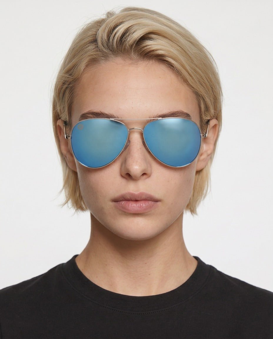 Nexus metal aviator sunglasses in Blue / Silver, blue lens on silver frame, worn by a woman, front view