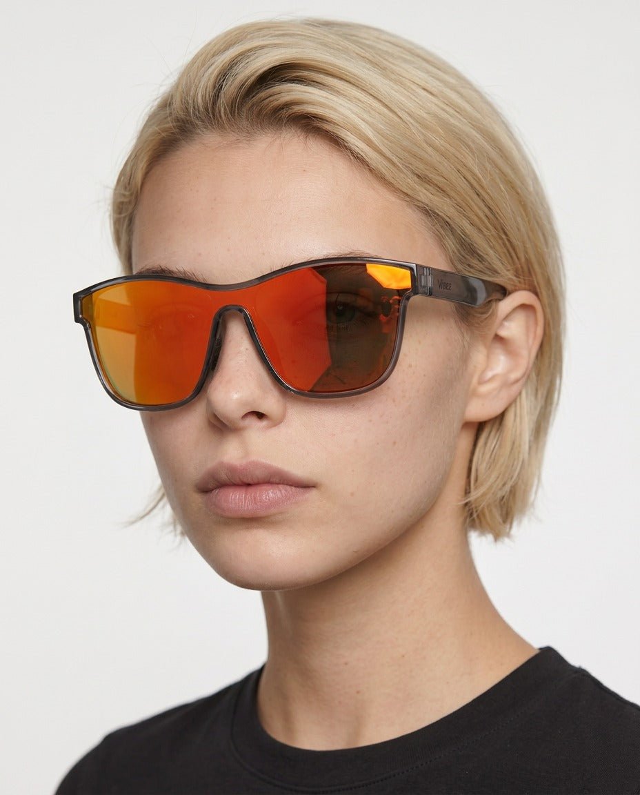 Radar performance wrap sunglasses in Red / Black, red lens on black frame, worn by a woman, front view