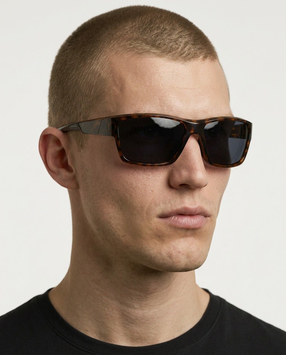 Specter slim wrap sunglasses in Black / Tortoise, black lens on tortoise frame, worn by a man, front view