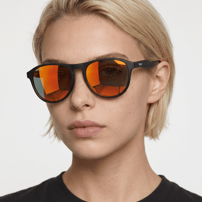 Orbit rounded aviator sunglasses in Orange / Black, orange lens on black frame, worn by a woman, front view