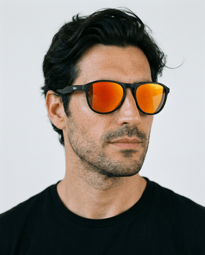 Orbit rounded aviator sunglasses in Orange / Black, orange lens on black frame, worn by a man, front view