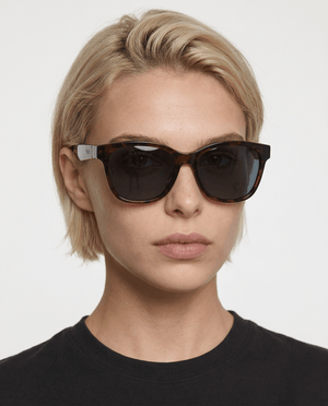 Delta 9 oversized round sunglasses in Black / Tortoise, black lens on tortoise frame, worn by a woman, front view